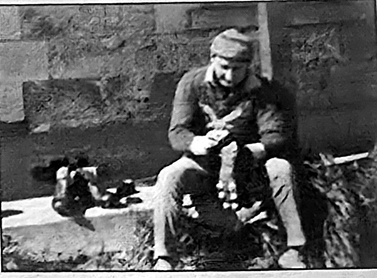 Neil Skeer at work in 1971, pictured seated on a step with football boots beside him