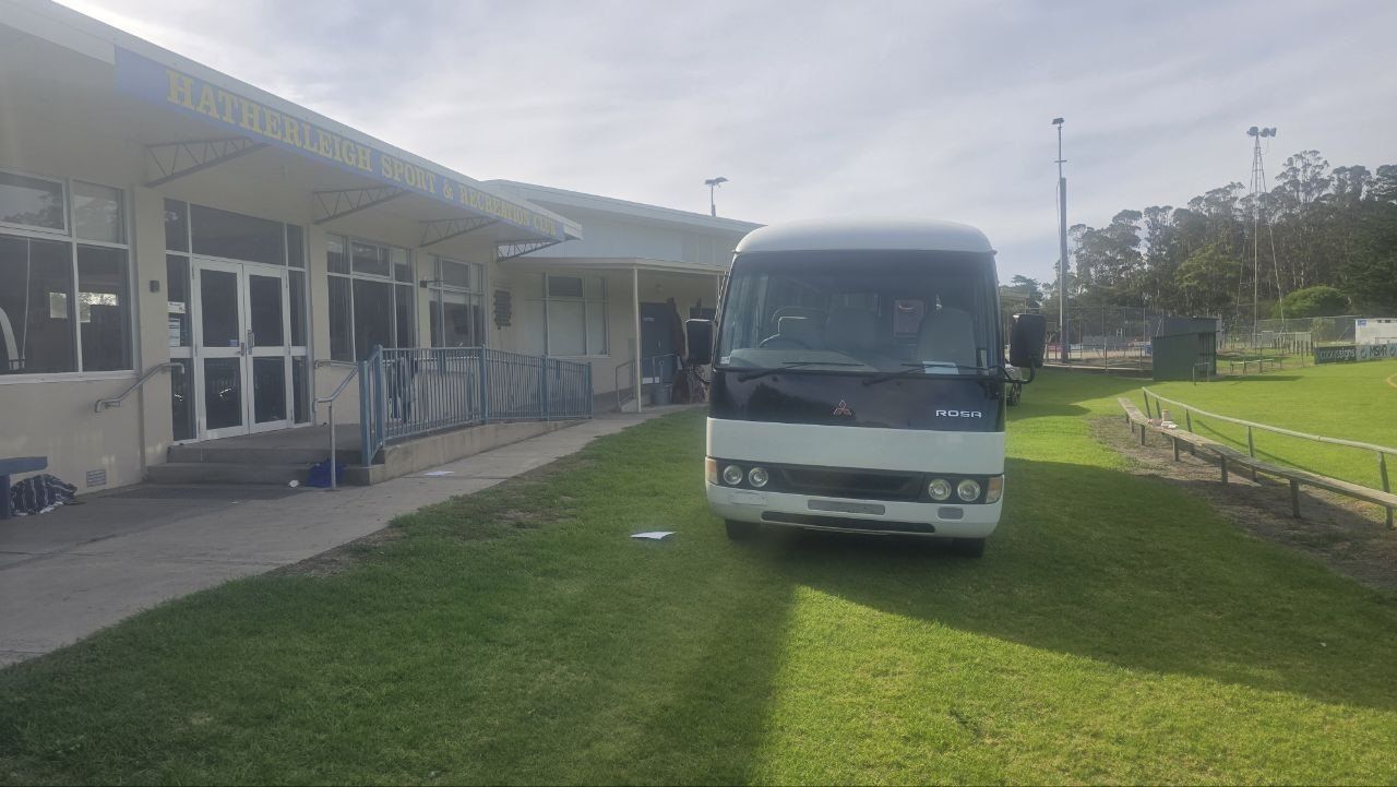 Front view of the Eagles Express, a Mitsubishi Rosa, on the grass outside the clubrooms
