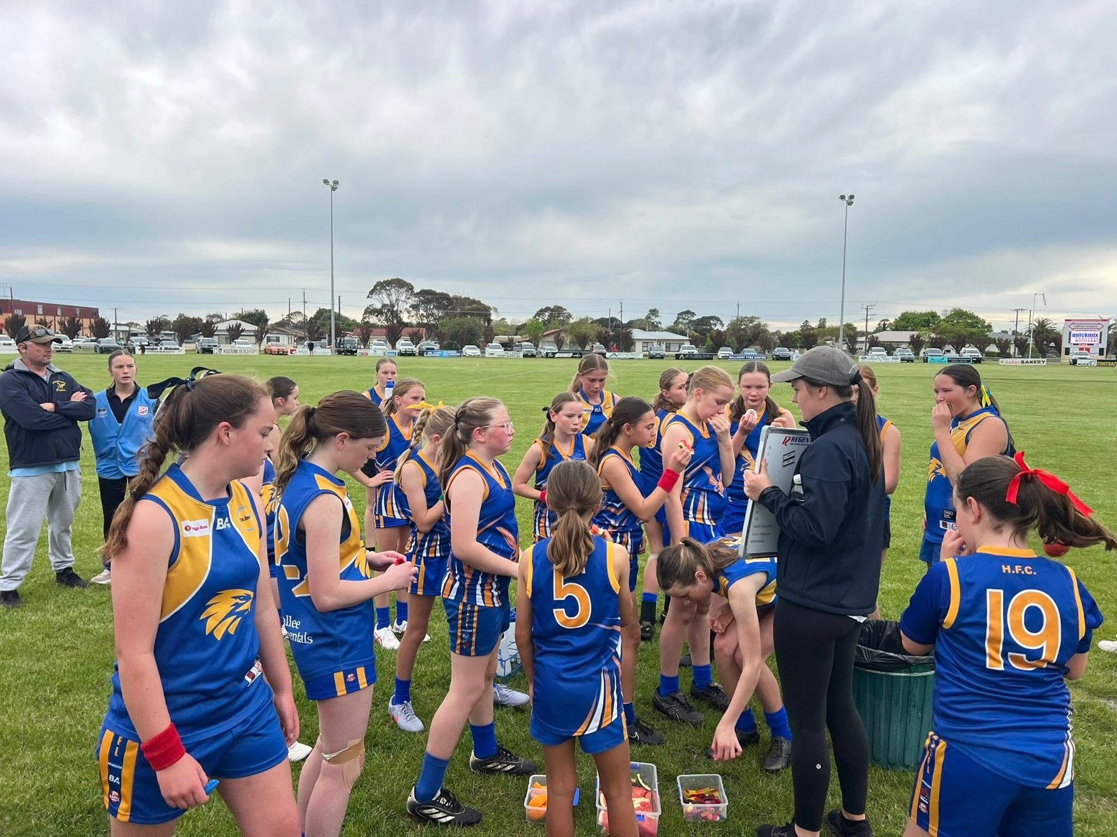 Hatherleigh girls gather round the coach's whiteboard at the break