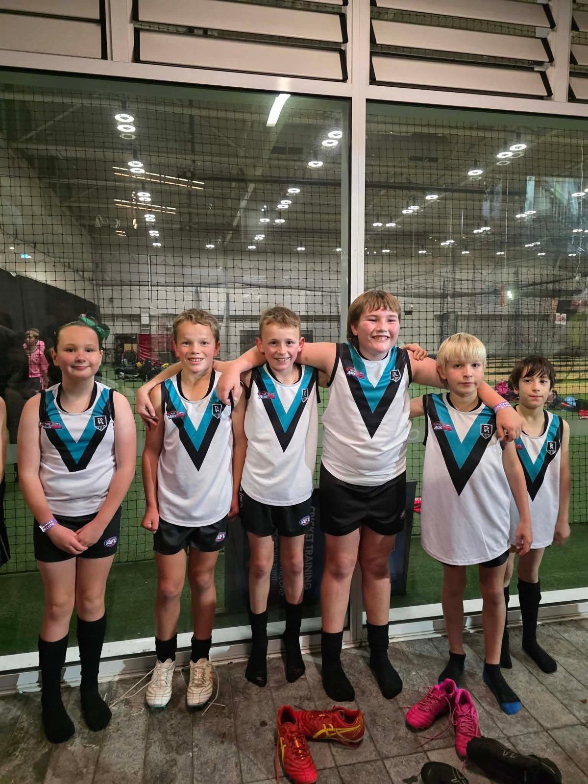 Hatherleigh juniors in Port Adelaide Little League guernseys before running out at Adelaide Oval, 2026
