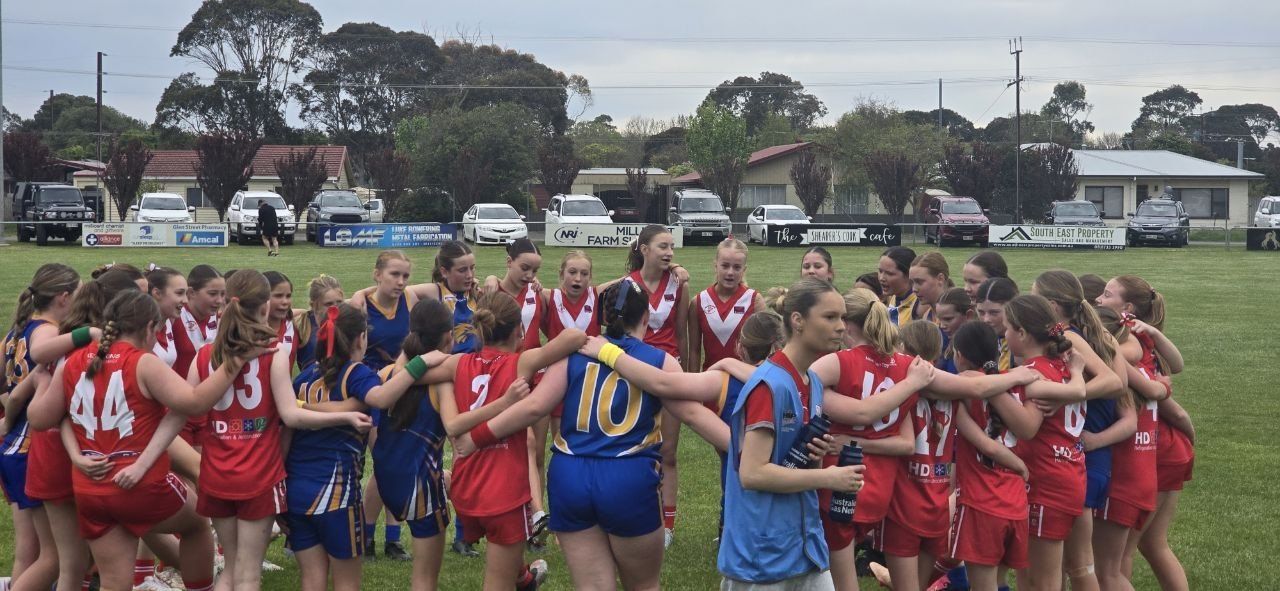 Hatherleigh and opposition U13 Girls players join arms in a combined huddle after the game