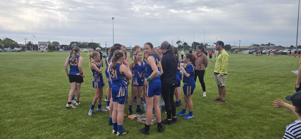 U13 Girls regroup on the ground between quarters