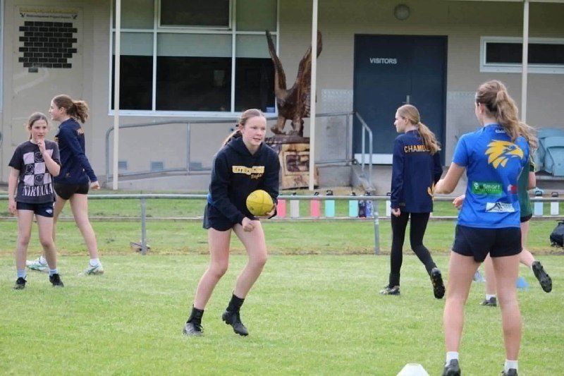 Girls football training at Hatherleigh, with the carved eagle sculpture in front of the clubrooms