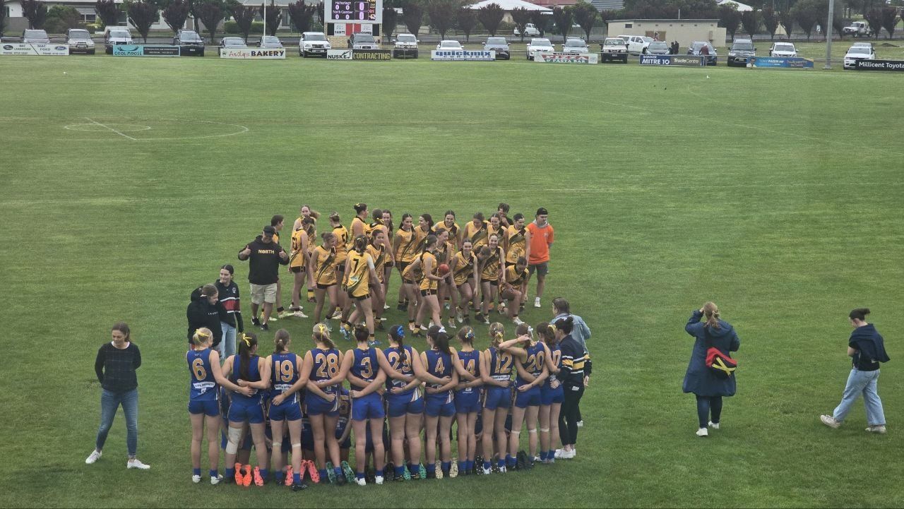 Hatherleigh U16 Girls huddle as North Gambier gather after the 2024 grand final