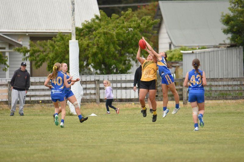 Hatherleigh U16 Girls player flies for a mark against a North Gambier opponent