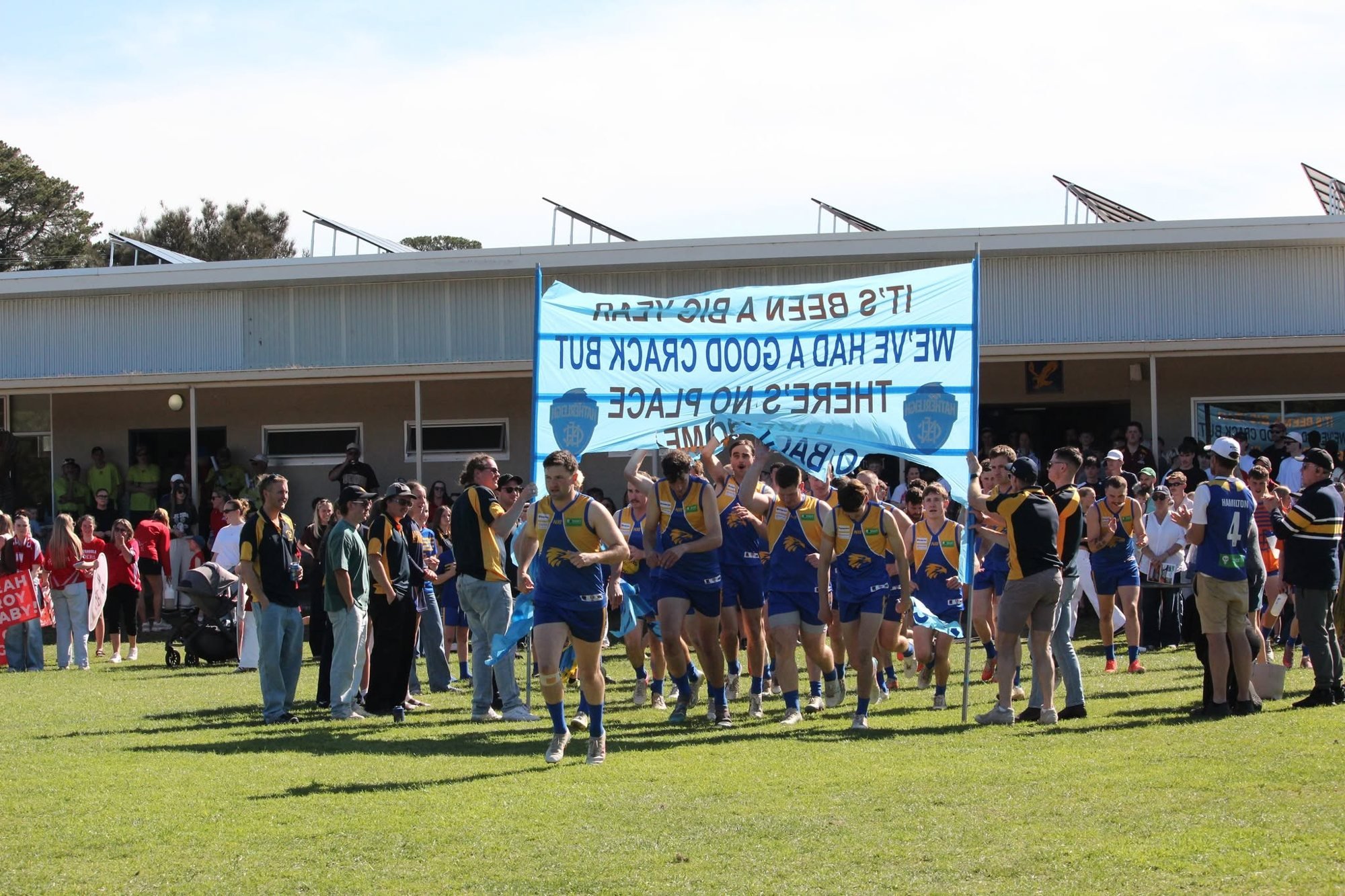 Hatherleigh footballers run through the banner in front of the clubrooms
