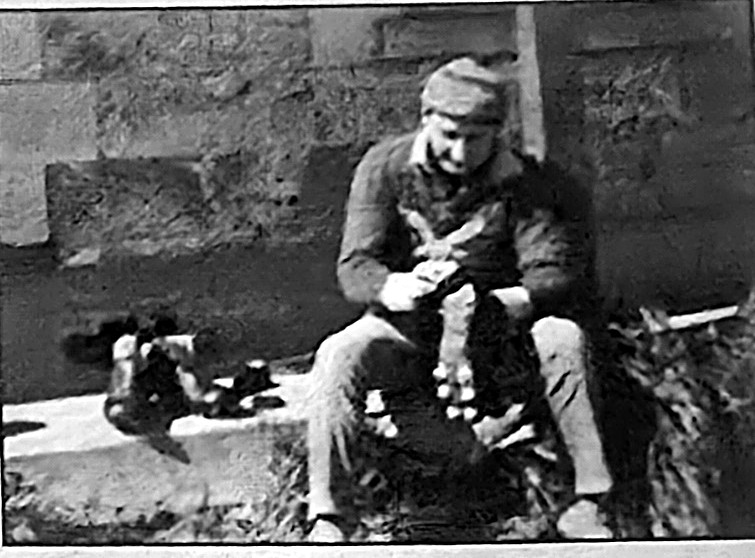 Neil Skeer at work in 1971, pictured seated on a step with football boots beside him